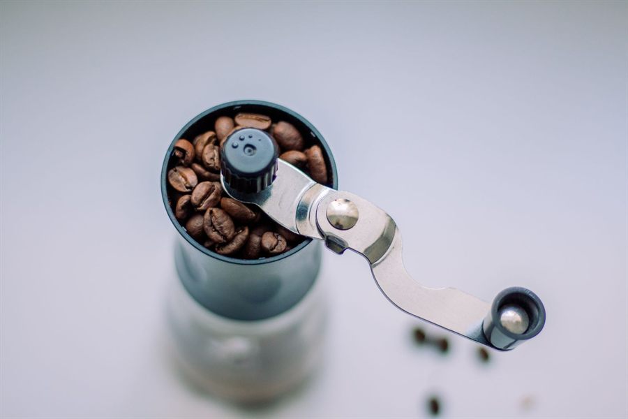 Manual coffee grinder filled with whole beans