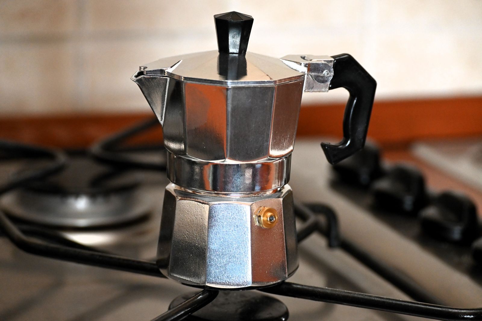 Aluminum stovetop moka pot sitting on a gas burner, one way to brew coffee without a coffee maker